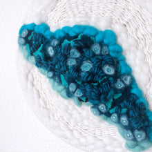 Load image into Gallery viewer, close up of round wall hanging with blue, teal, aqua, black, and creamy white fibers